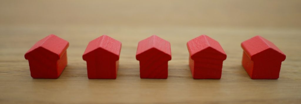 Maquetas de viviendas alineadas que representan la comparación entre precio deseado y valor de mercado