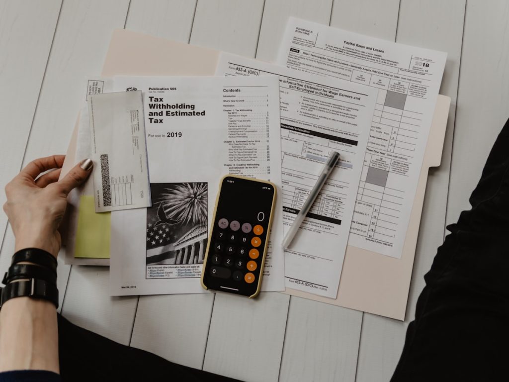 Documentos bancarios y calculadora para revisar la deuda hipotecaria pendiente antes de vender