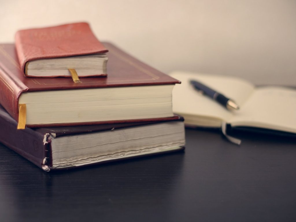 Libros jurídicos y pluma que representan la escritura de propiedad de una vivienda