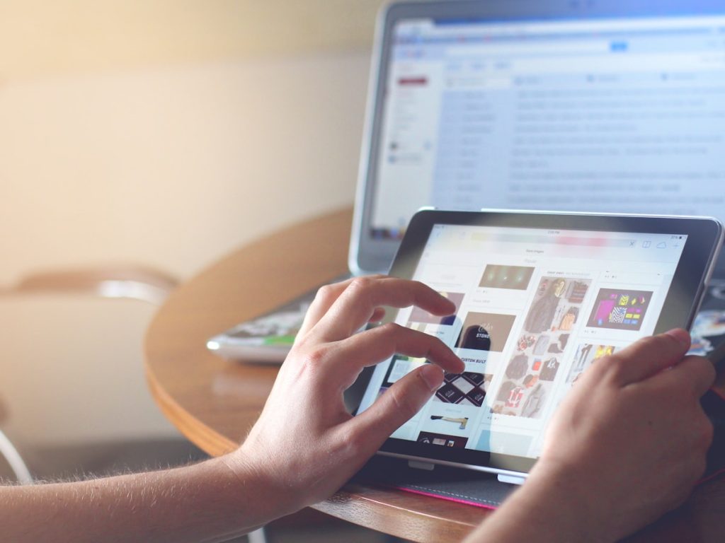 Comprador revisando anuncios de viviendas en una tablet antes de solicitar una visita