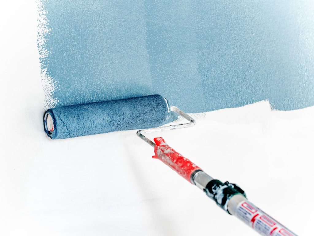 Rodillo de pintura durante una pequeña mejora que revaloriza la vivienda antes de venderla
