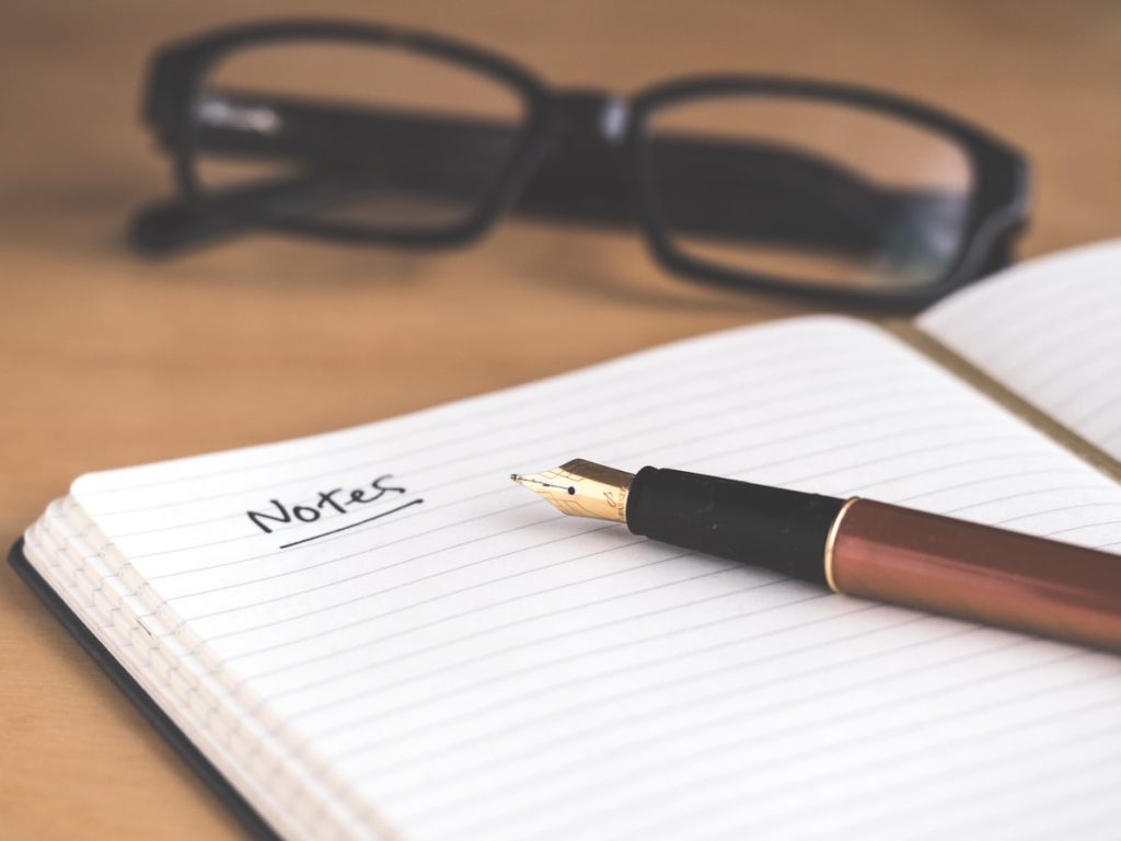 Cuaderno y notas para preparar la documentación de la vivienda antes de ponerla a la venta