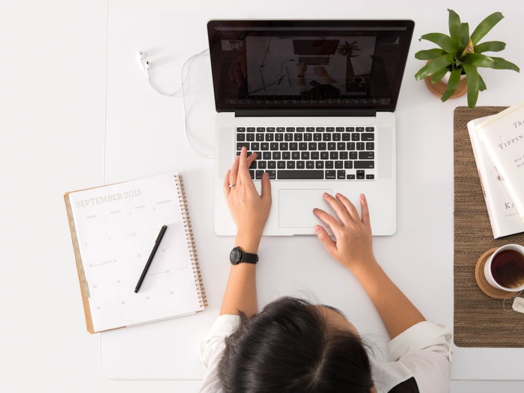 Mesa de trabajo con agenda y ordenador para preparar la documentación antes de vender la vivienda