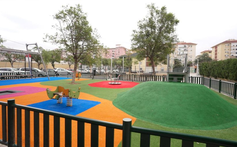 Parque infantil y zonas verdes entre bloques residenciales en Parque Alcosa, Sevilla