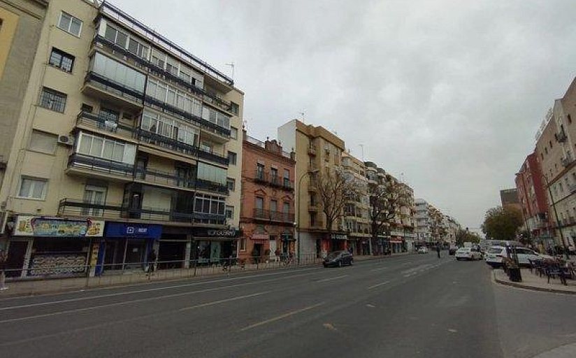 Avenida con bloques residenciales y comercios en el barrio de San Pablo, Sevilla